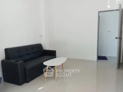 Minimalist living room with sleek black sofa and modern coffee table