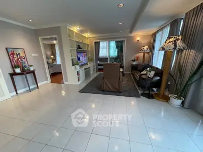 Spacious living room with elegant decor and natural light, featuring a cozy seating area and modern furnishings.