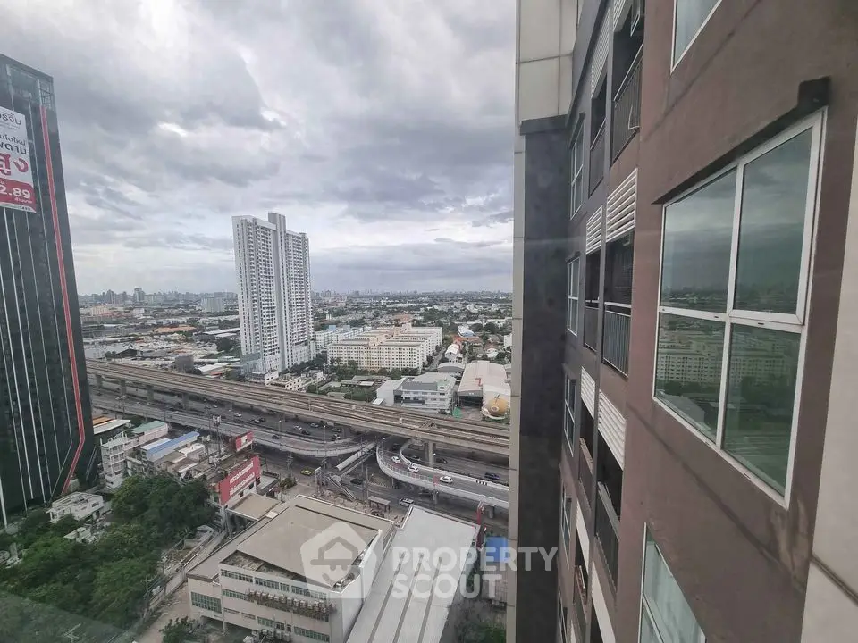 Stunning cityscape view from high-rise apartment window showcasing urban skyline and highways.