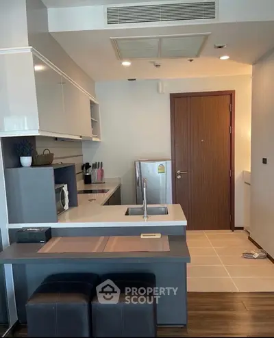 Modern kitchen with sleek design, featuring built-in appliances and stylish cabinetry in a compact layout.