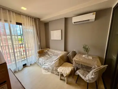 Modern living room with balcony, air conditioning, and stylish furniture in a cozy apartment.