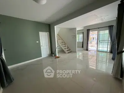 Spacious living room with glossy tiled floors and large windows offering natural light.