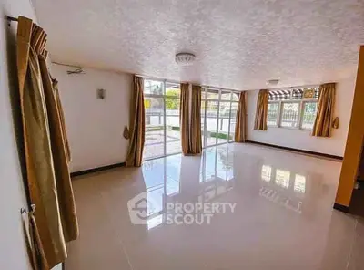 Spacious living room with large windows and glossy floor