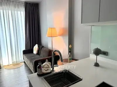 Modern living room with sleek kitchen and cozy sofa, perfect for urban living.