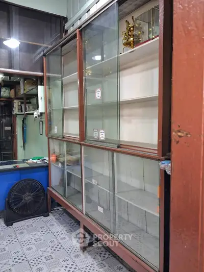 Spacious storage room with glass cabinets and tiled flooring, ideal for organizing and displaying items.