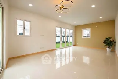 Spacious modern living room with large windows and elegant lighting