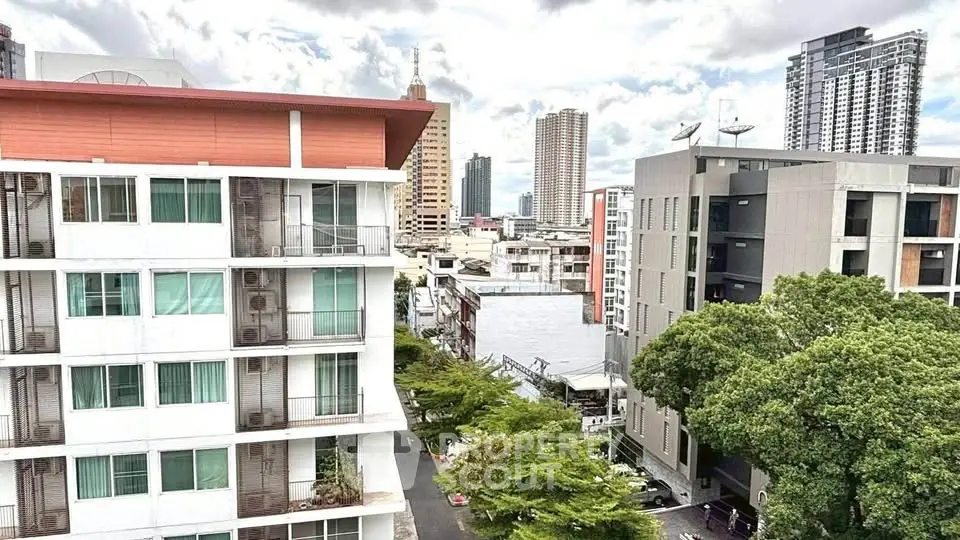 Stunning urban view of modern high-rise buildings with lush greenery and city skyline.