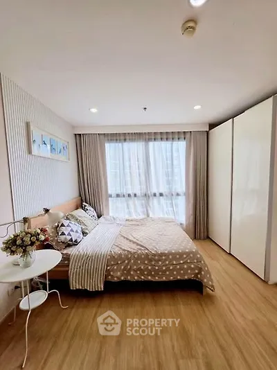 Cozy bedroom with large window and modern decor in a stylish apartment.