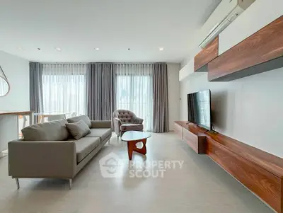 Spacious modern living room with elegant furniture and large windows for natural light.