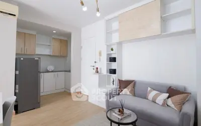 Modern living room with cozy sofa and stylish kitchen area in open layout apartment.