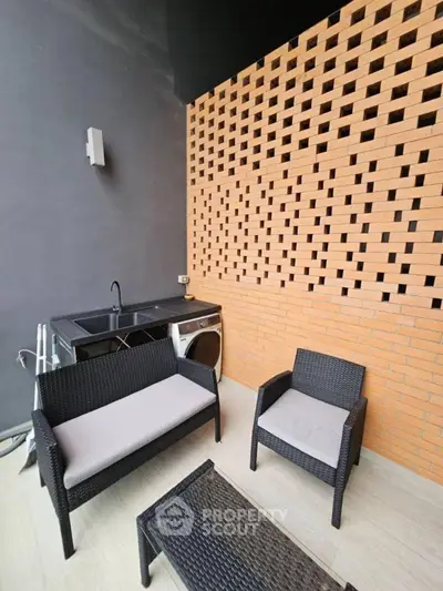 Stylish outdoor patio with modern seating and laundry area