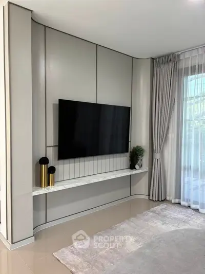 Modern living room with sleek TV setup and elegant curtains