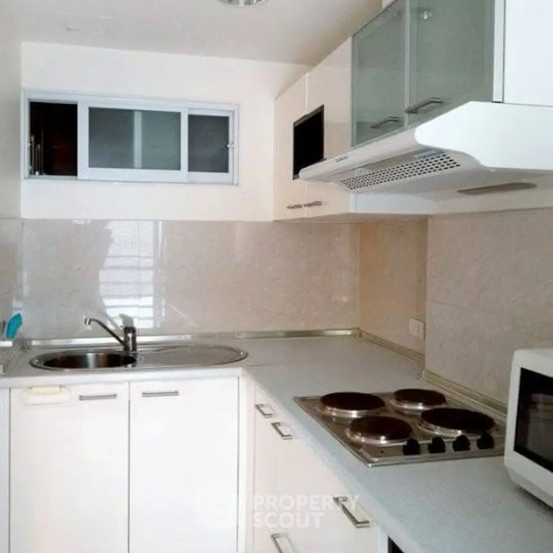 Modern compact kitchen with sleek cabinets and electric stove