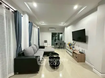 Modern living room with sleek furniture and dining area, ideal for contemporary living.