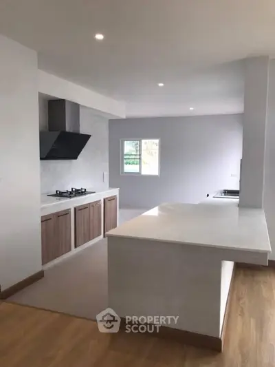 Modern kitchen with sleek countertops and gas stove in open layout design.