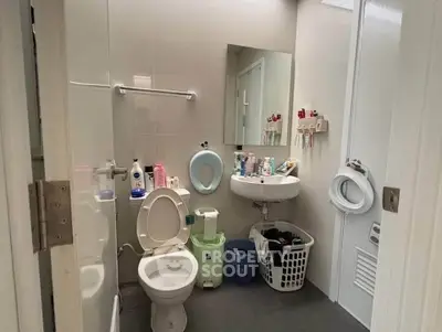 Compact bathroom with essential fixtures and storage baskets, ideal for efficient space utilization.