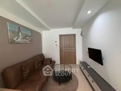 Modern living room with brown leather sofa and wall-mounted TV, featuring minimalist decor.