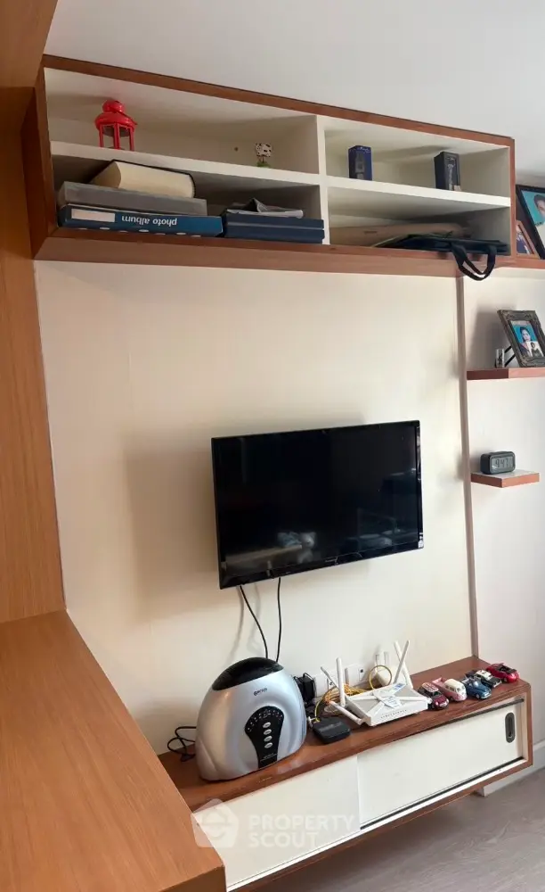 Modern living room with wall-mounted TV and stylish shelving unit