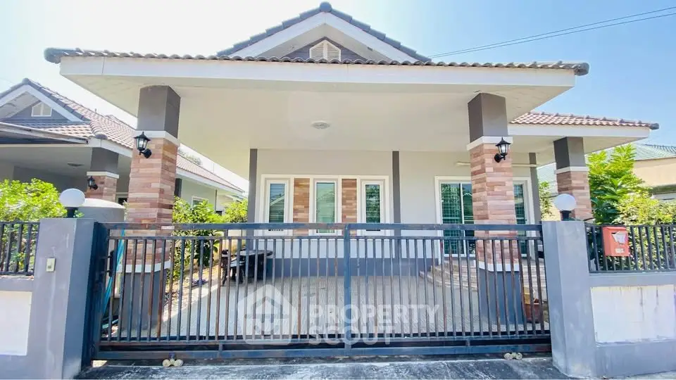 Charming single-story house with gated entrance and modern exterior design.
