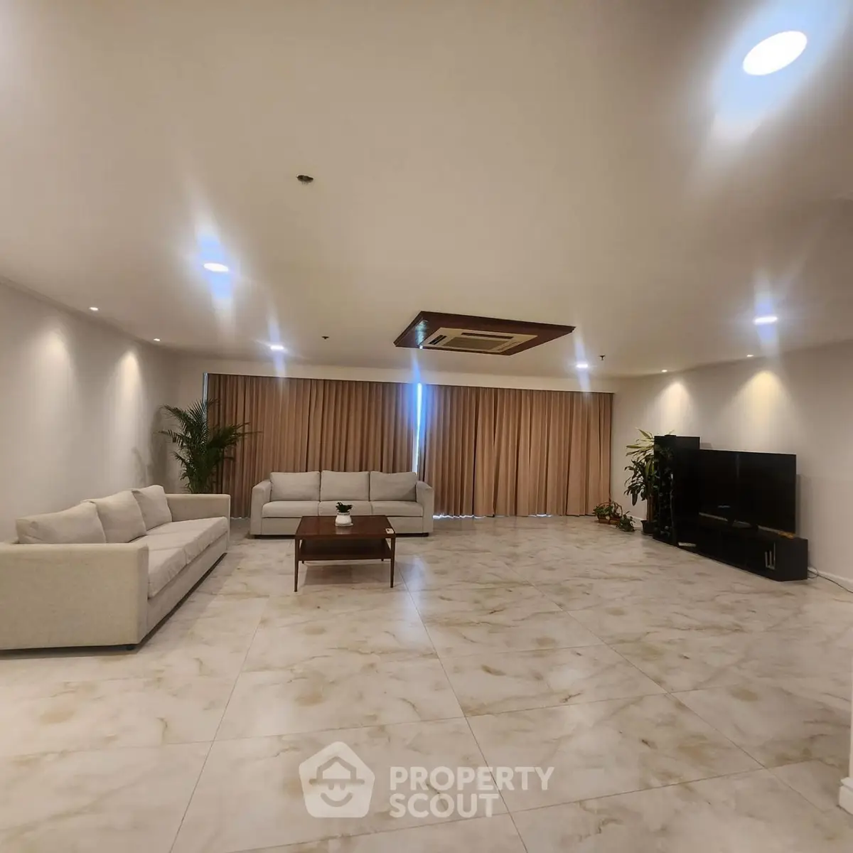 Spacious modern living room with elegant sofas and large tile flooring