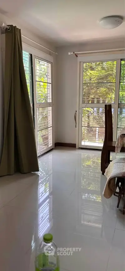 Bright living room with large windows and glossy floor tiles