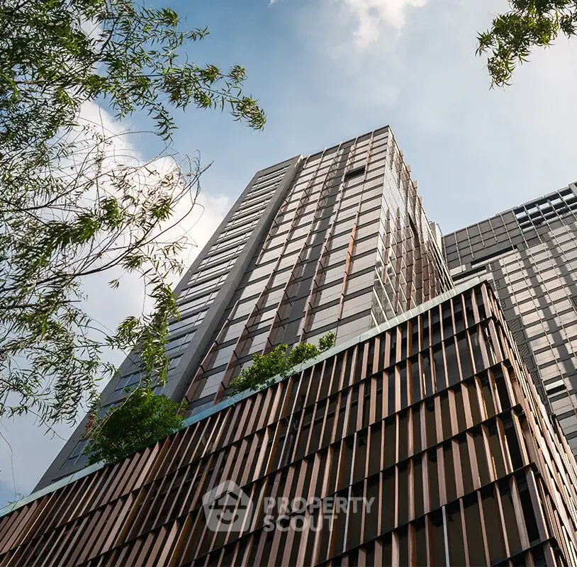 Modern high-rise building with sleek design and lush greenery