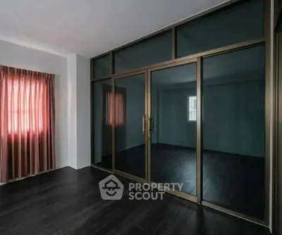 Spacious room with dark flooring and large glass sliding doors