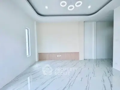 Modern minimalist living room with marble flooring and unique ceiling lights.