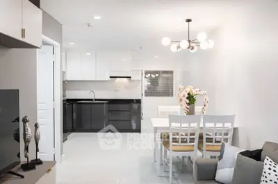 Modern open-plan kitchen and dining area with sleek design and elegant lighting.