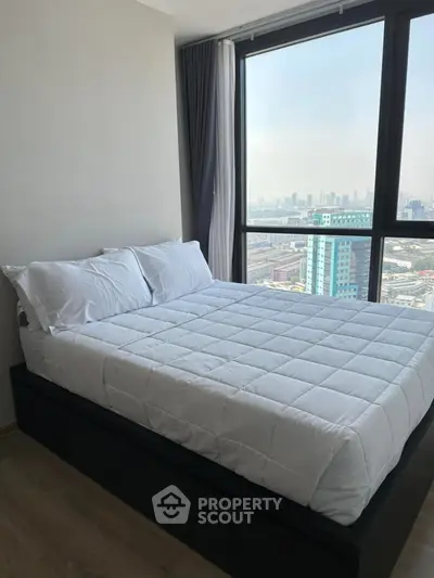 Modern bedroom with city view and large window, featuring a cozy bed and minimalist decor.