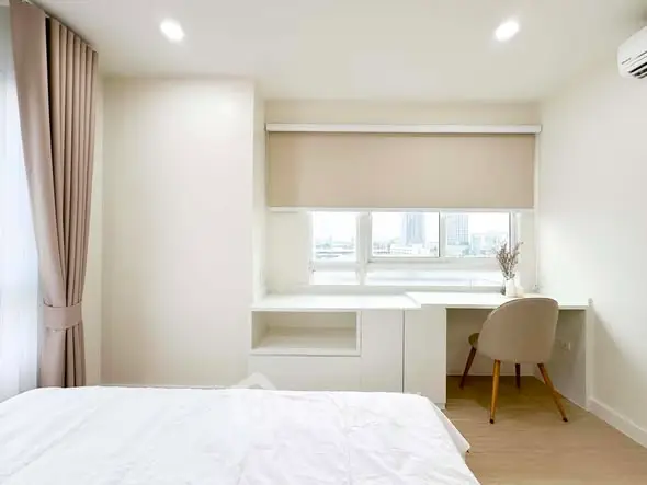 Bright and modern bedroom with study area and city view, perfect for urban living.