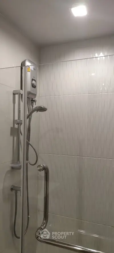 Modern bathroom shower with sleek design and safety rail