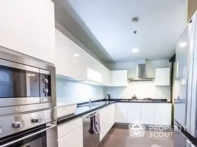 Modern kitchen with sleek white cabinets and stainless steel appliances