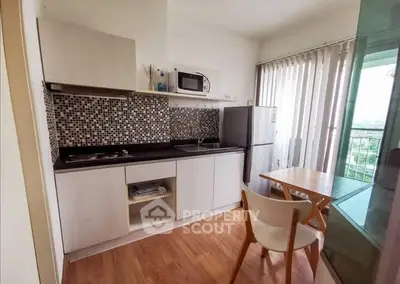 Modern kitchen with sleek design, featuring mosaic backsplash, compact appliances, and a cozy dining area with natural light.