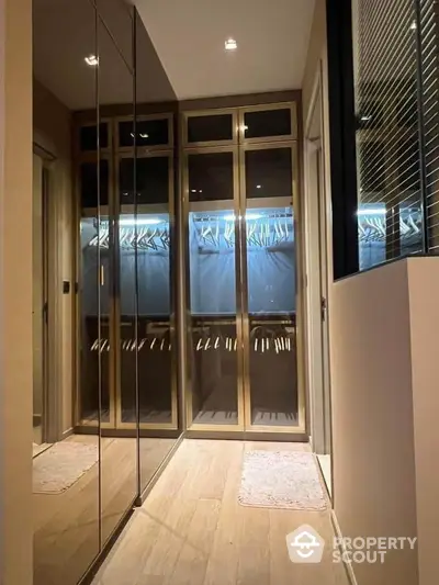 Elegant walk-in closet with mirrored doors and wooden flooring