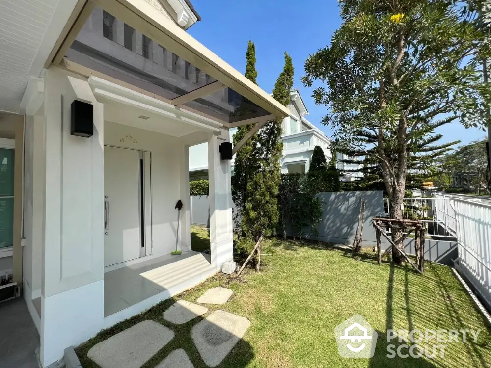 Charming modern home entrance with lush garden and pathway