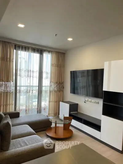 Modern living room with stylish furniture and large window offering natural light