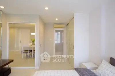 Modern bedroom with glass partition and dining area view, sleek design and cozy ambiance.