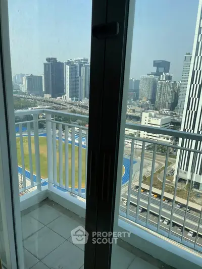 Stunning city view from high-rise apartment balcony with modern railing.