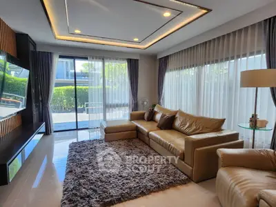 Luxurious living room with modern leather sofa and large windows offering natural light.