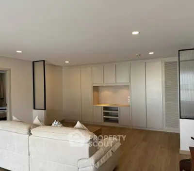Spacious modern living room with elegant built-in storage and cozy seating area.