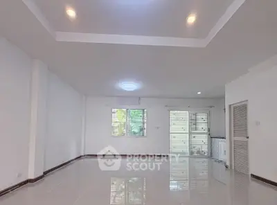 Spacious empty living room with glossy floors and large windows in modern home