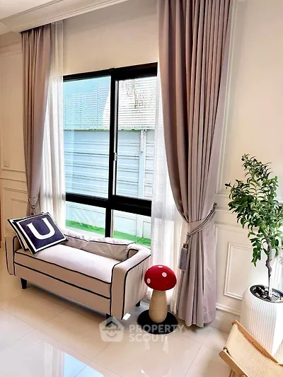 Elegant living room with stylish sofa, large window, and chic decor
