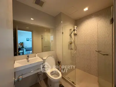 Modern bathroom with glass shower and sleek fixtures in a contemporary apartment.