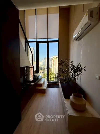 Modern living room with high ceilings and city view through large windows.