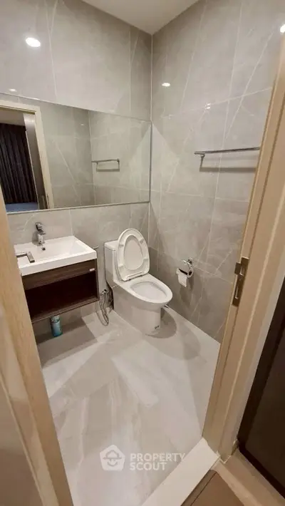 Modern bathroom with sleek design and large mirror in a contemporary apartment.