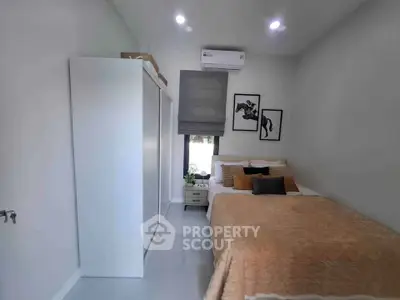 Cozy bedroom with modern decor, featuring a comfortable bed, stylish artwork, and ample storage space.