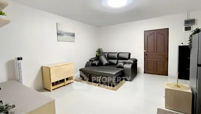 Modern living room with black leather sofa and minimalist decor