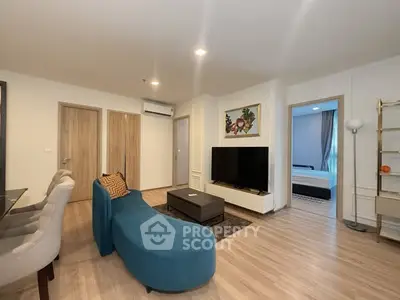 Modern living room with stylish furniture and open view to bedroom