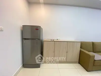 Modern living room with sleek fridge and stylish cabinetry